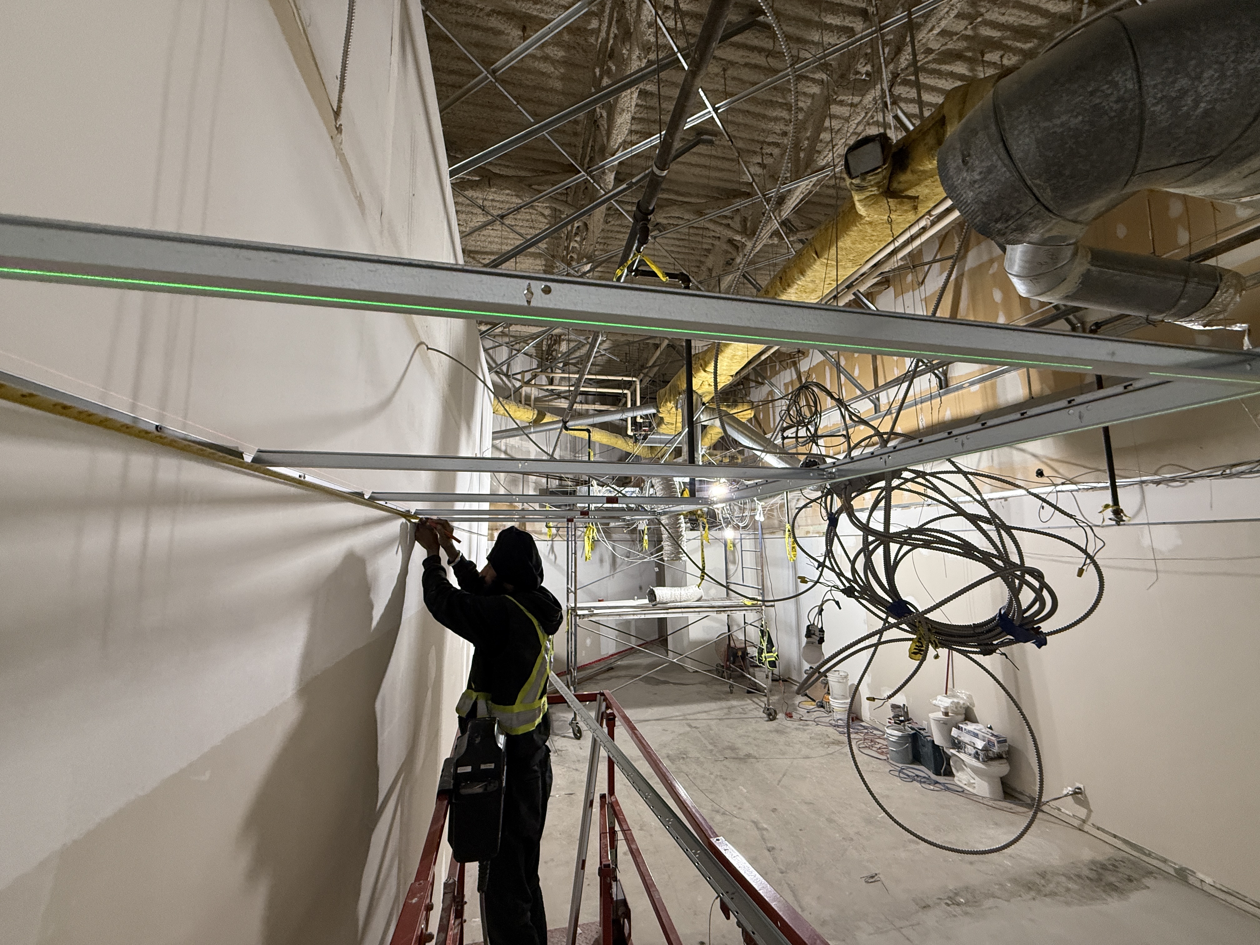 Steelskin Drywall worker installing suspended ceiling grid
