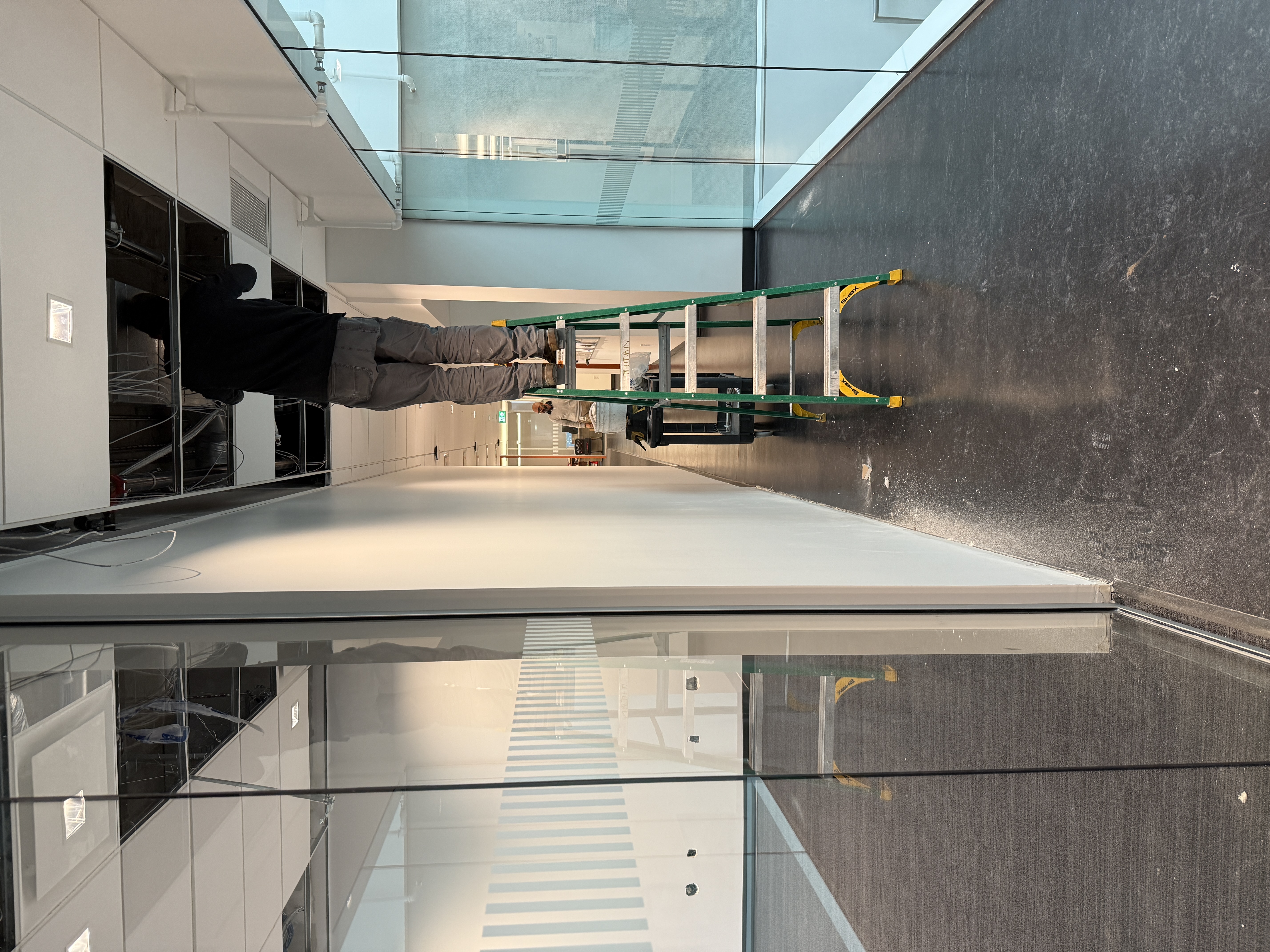 Commercial T-bar ceiling work above a glazed office corridor in Surrey