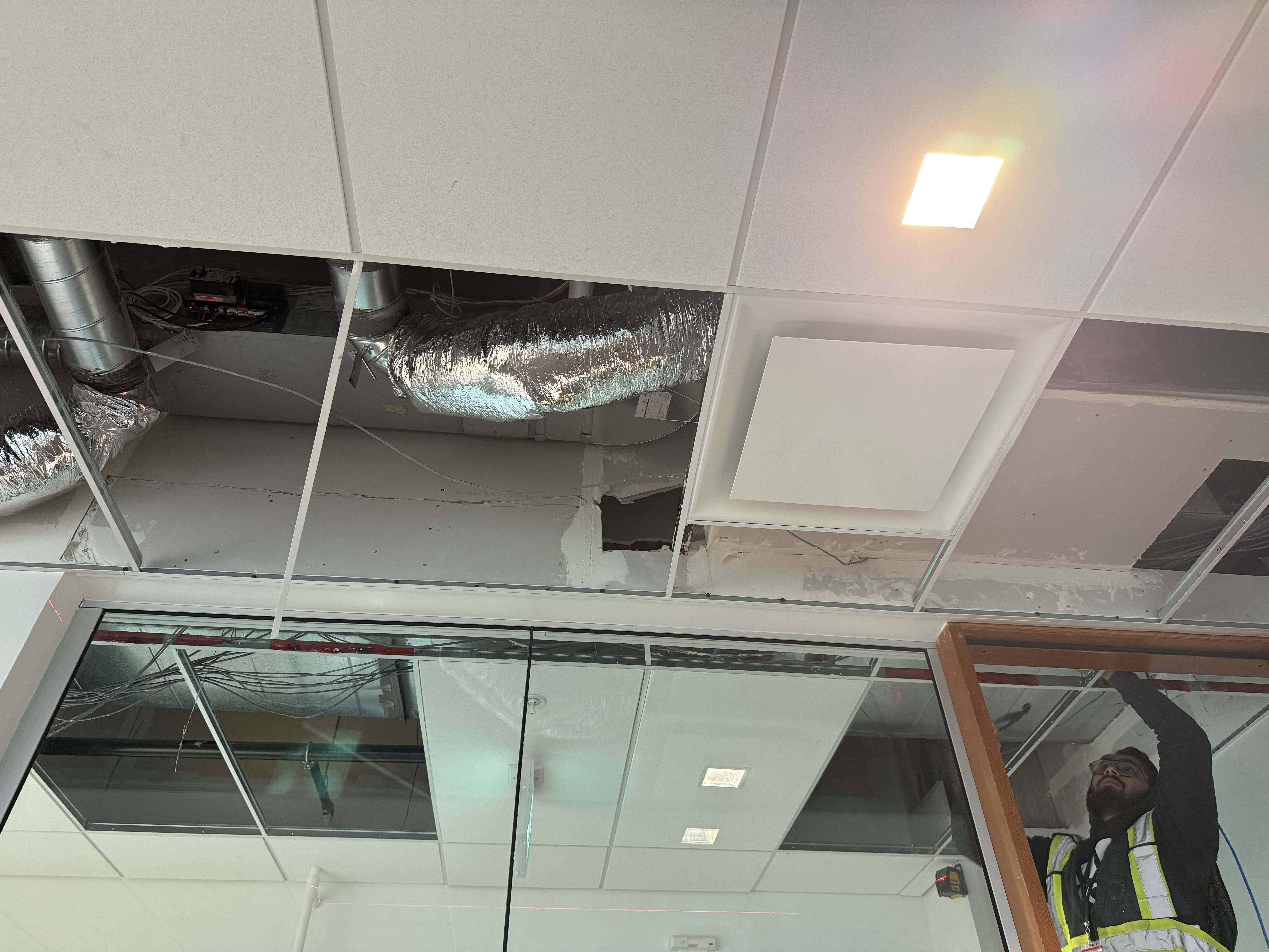 Acoustic ceiling tiles being reinstalled after a commercial renovation