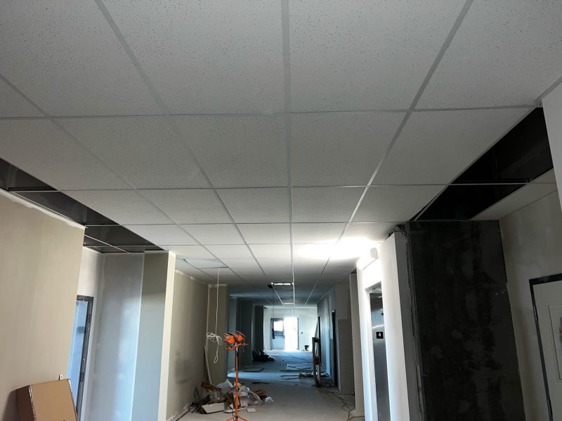 Completed white acoustic ceiling tiles in a suspended T-Bar grid